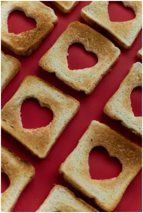 High angle of parts of bread with cut hearts in ce