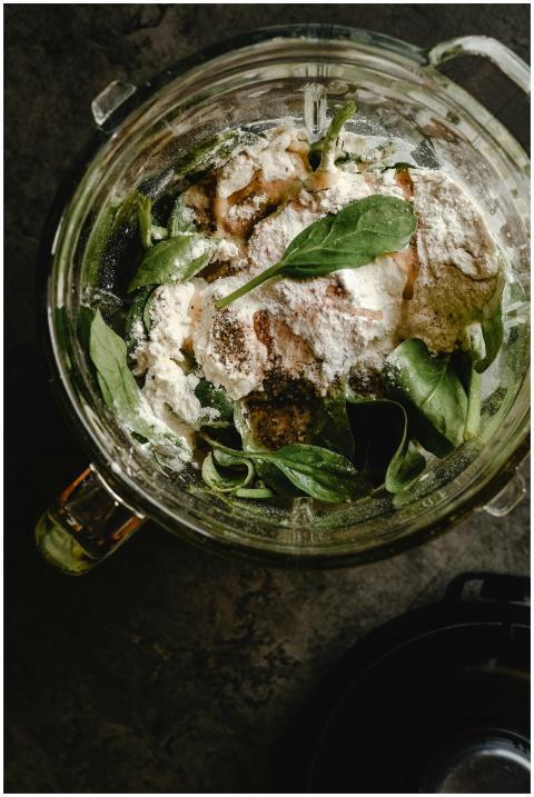 Fresh spinach leaves with flour and ingredients in