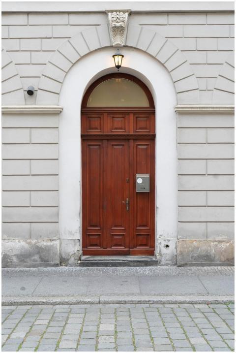 A classic wooden door set in a white stone wall on