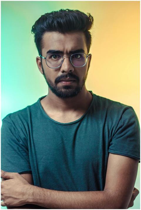 A thoughtful adult man with eyeglasses posing for