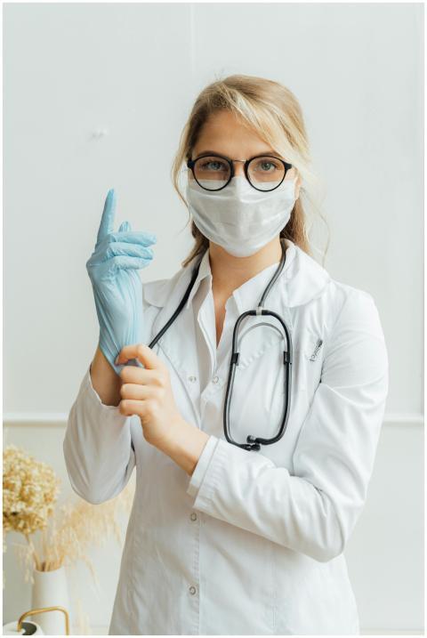 Female doctor wearing eyeglasses, face mask, and s