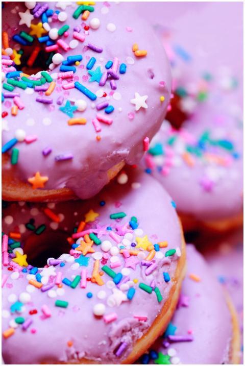A close-up of vibrant donuts with purple icing and