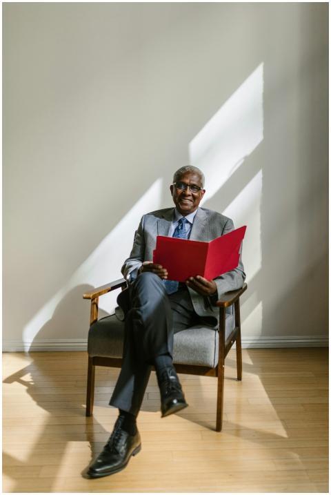 Elderly businessman sitting with a folder in brigh