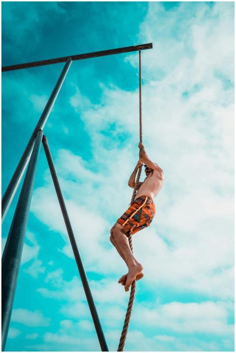 A man enjoys rope climbing on a sunny day at Santa