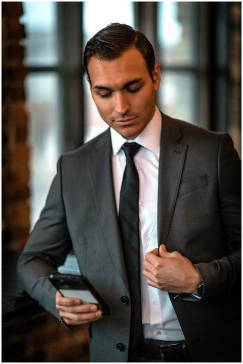 Young man in an elegant suit, looking down at his