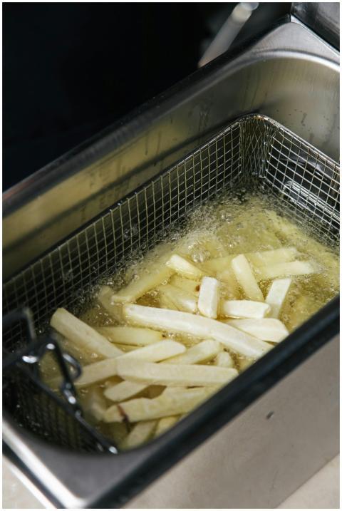 Close-up of french fries cooking in a deep fryer w