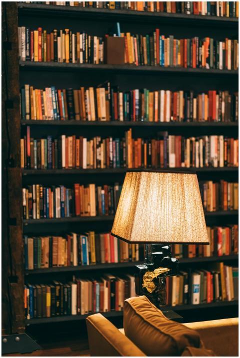 Warmly lit library with bookshelves and a reading