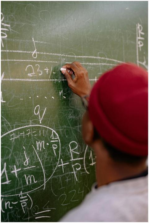 Person writing complex mathematical equations on a