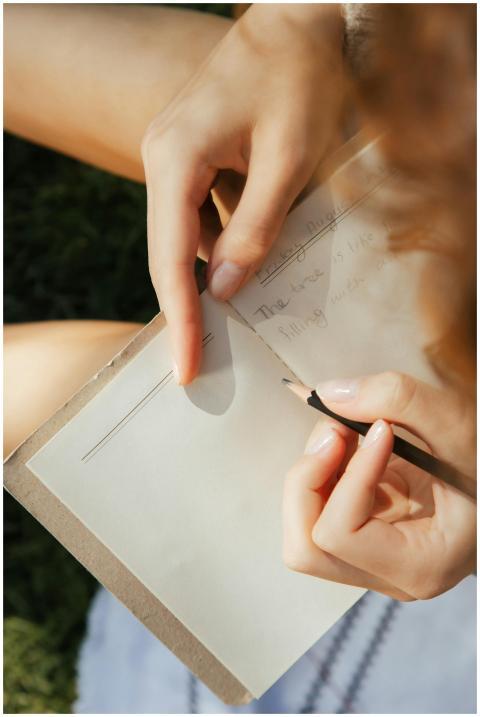Close-up of a woman writing in a notebook outdoors