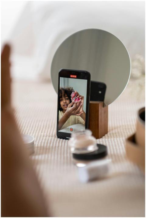 Young woman vlogger reviews beauty products in fro