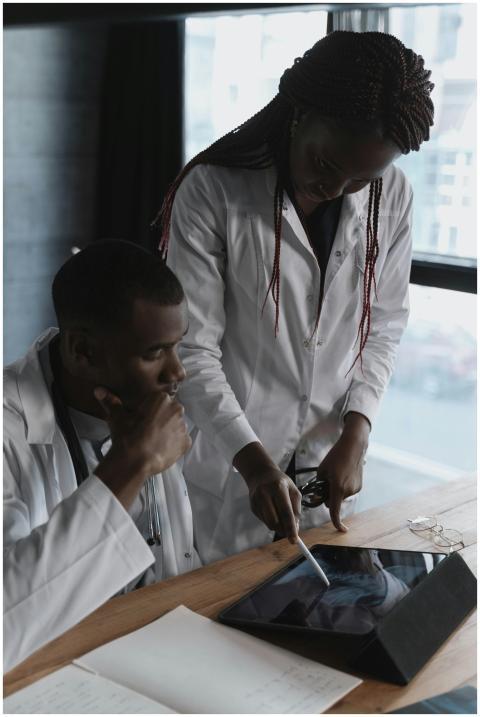 Two doctors in lab coats focus on research in a mo