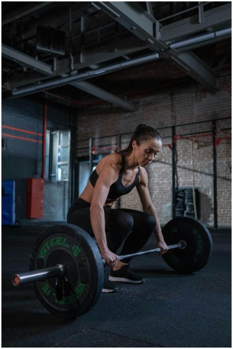 A determined woman lifts a barbell during a weight