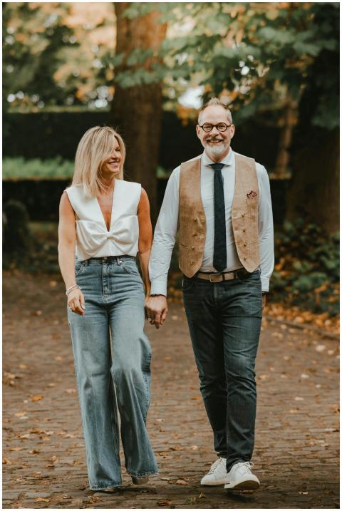 Smiling couple walking hand in hand in a serene pa
