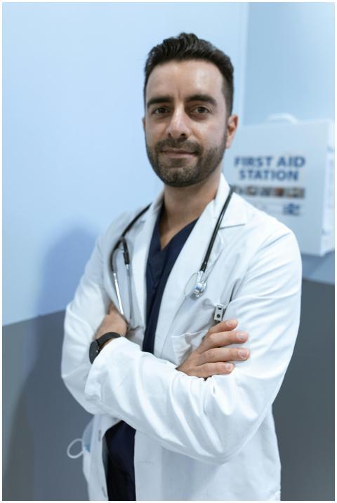 A confident male doctor with crossed arms, wearing