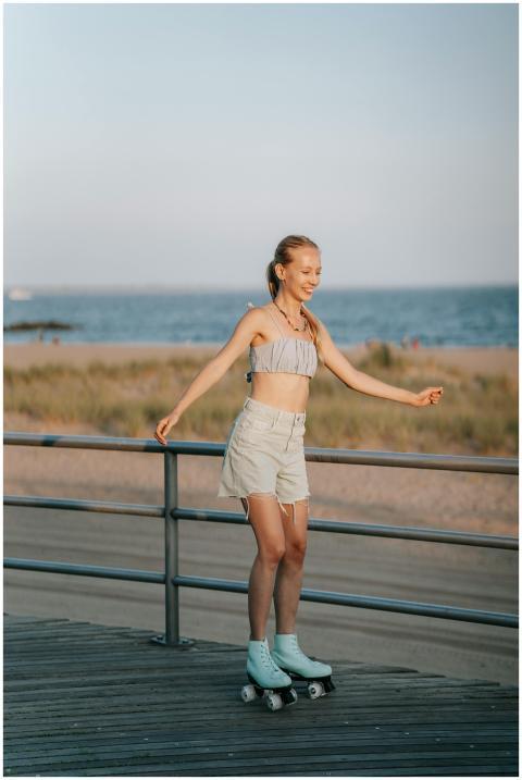 Smiling woman roller skating on a boardwalk by the