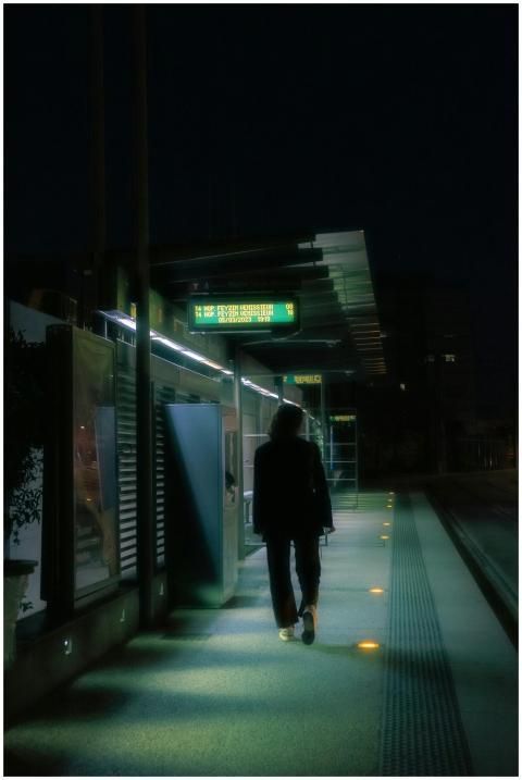 Silhouetted figure walking at night in an urban st
