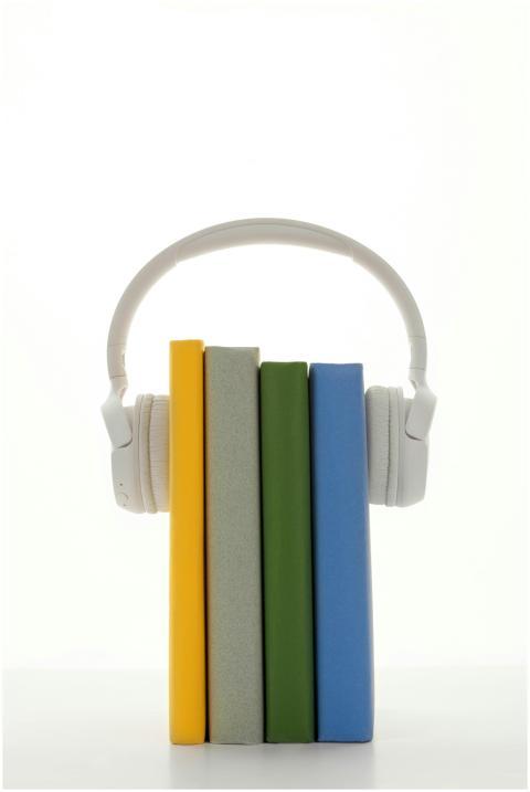 A stack of colorful books with headphones, symboli