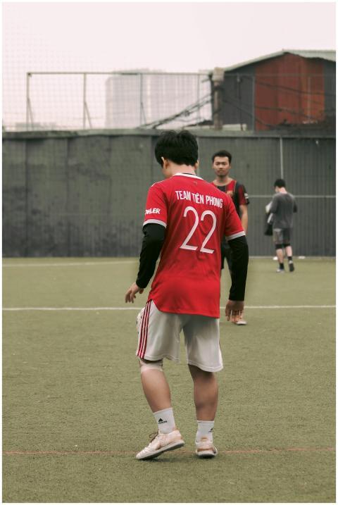 Back view of a soccer player in a red jersey durin