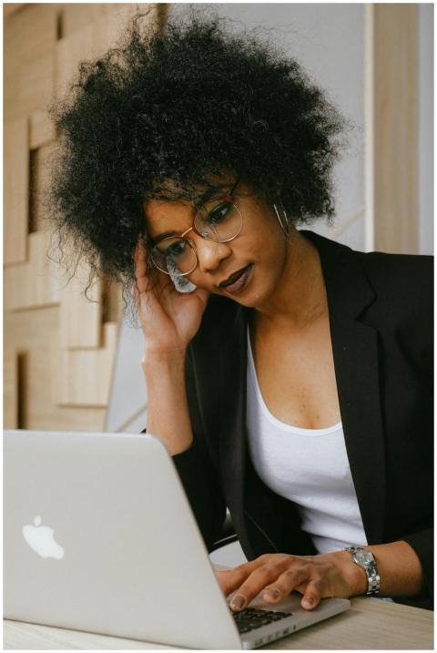 Businesswoman with afro hairstyle working on a lap