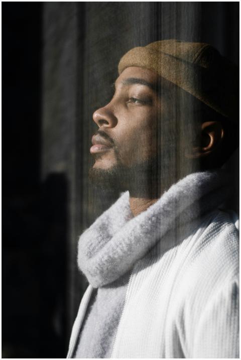 A pensive man in stylish winter wear gazes thought