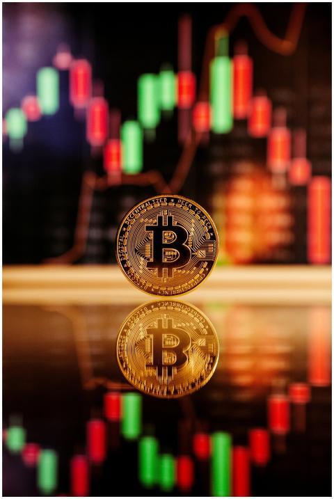 Golden Bitcoin standing in front of a financial ch