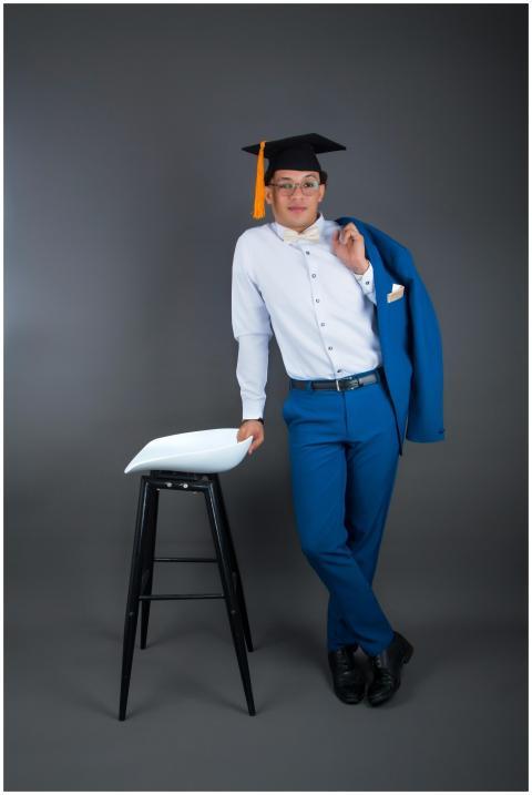 Young man posing elegantly in a graduation outfit