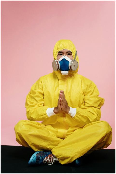 Man in full protective gear meditating on a pink b
