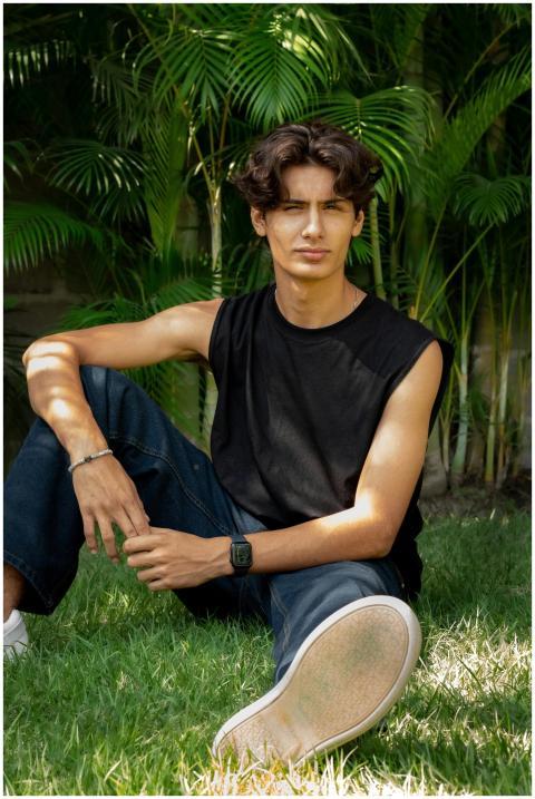 A relaxed young adult sitting on grass, enjoying t