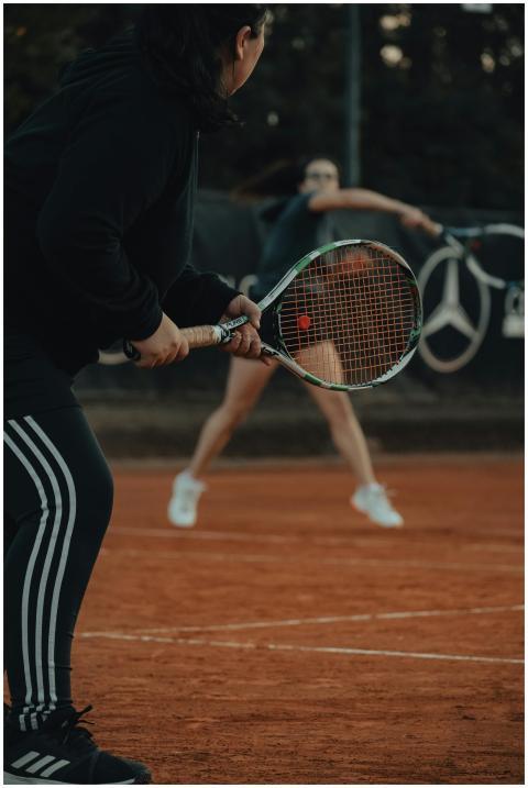 Two women engaged in a dynamic tennis match on a c