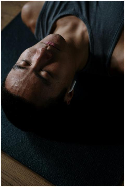 Shirtless man meditating indoors with headphones a