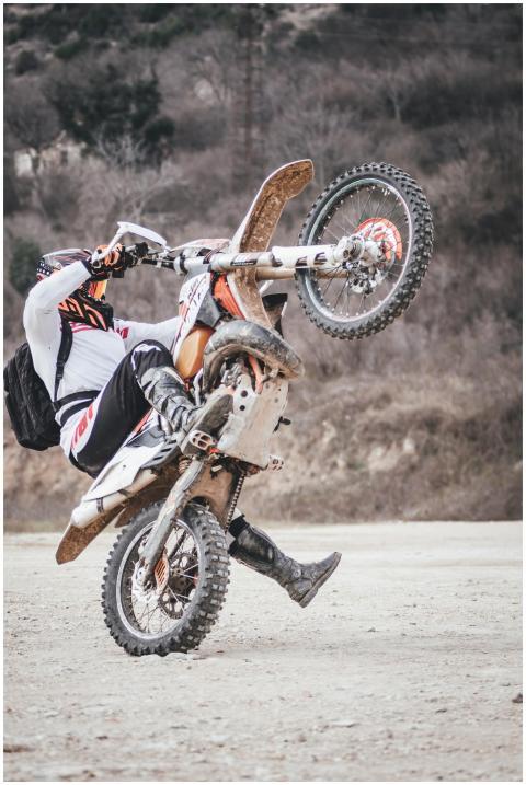 Exciting motocross wheelie on a dirt track, showca