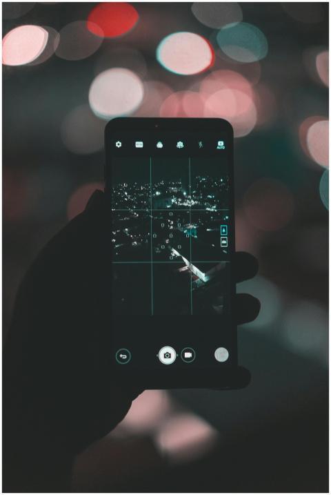 A smartphone capturing a stunning cityscape at nig