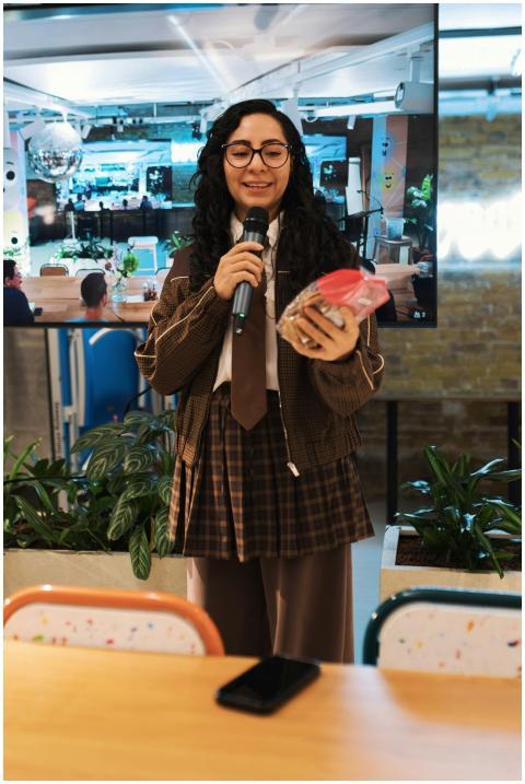 Young woman speaking into microphone holding a gif