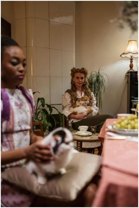 Two women enjoying tea and company of cats in a co