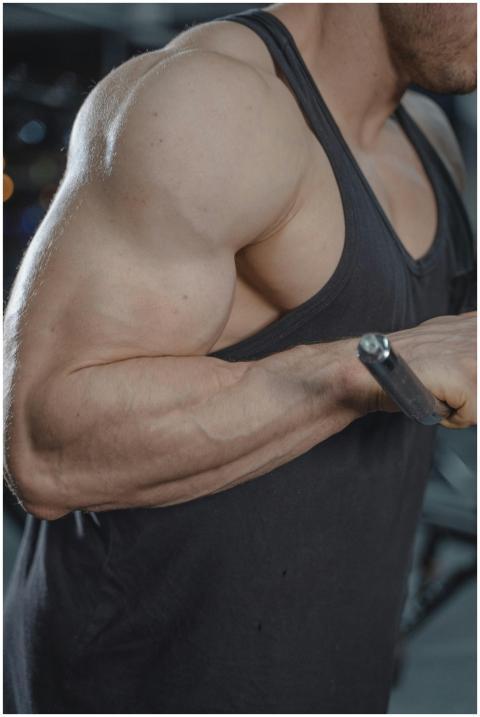 Close-up of a muscular man flexing in a black tank