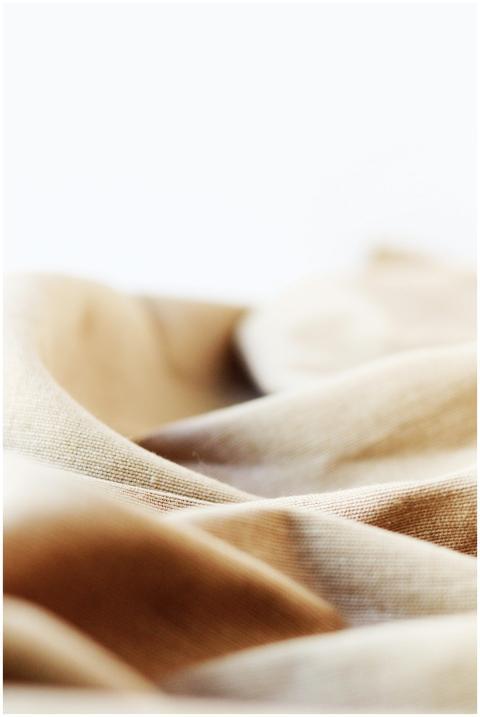 A detailed close-up of beige linen fabric showcasi