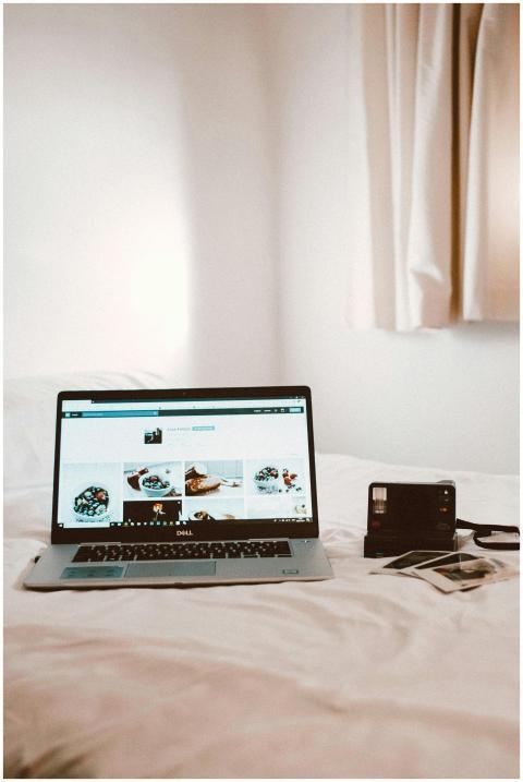 Cozy bedroom with a laptop and vintage camera on a