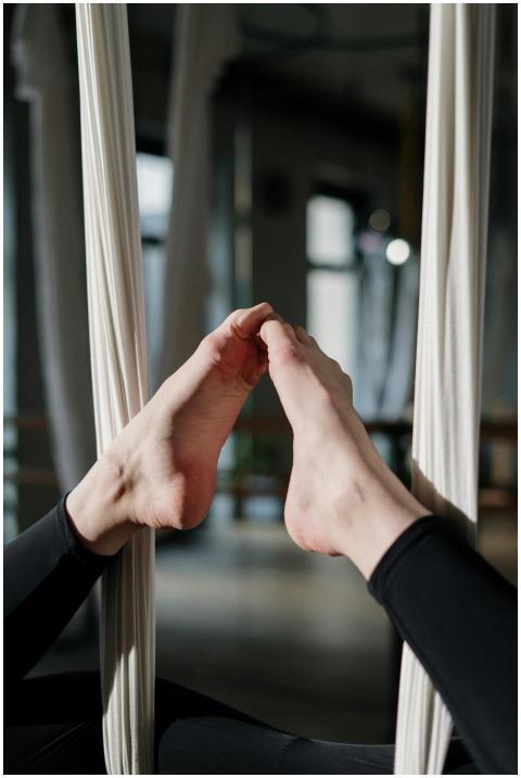 Close-up of feet in suspended aerial yoga pose, sh