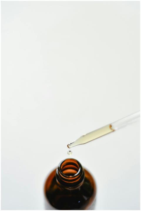 Close-up of a brown glass dropper bottle with a dr