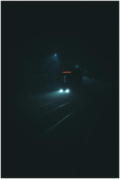 Atmospheric nighttime shot of a tram on foggy city