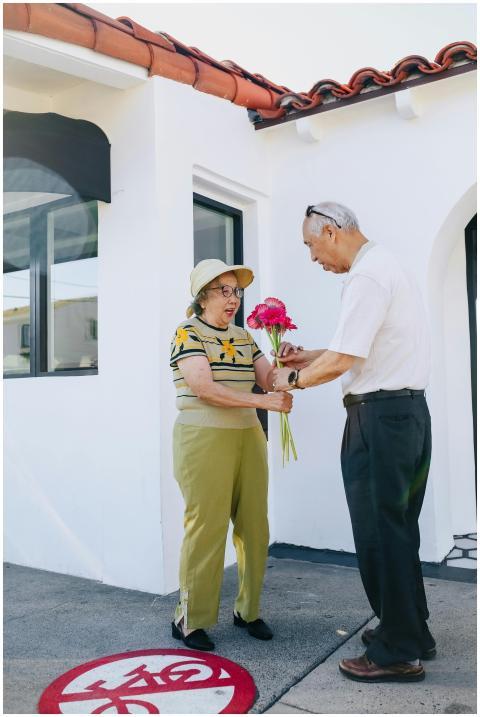 Senior couple exchanging flowers outdoors, capturi