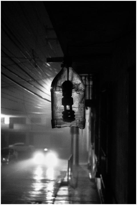 Moody black and white photo of a rainy street with