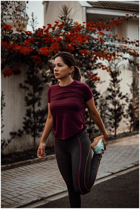 A woman stretches before a run on an outdoor pathw