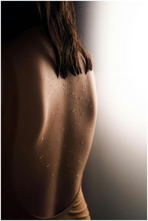 Artistic photo capturing water droplets on a woman
