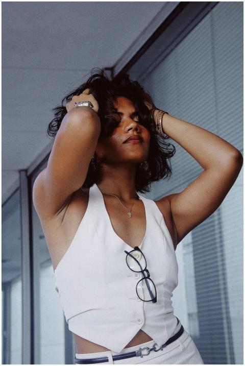 Stylish woman in a white top posing with glasses i