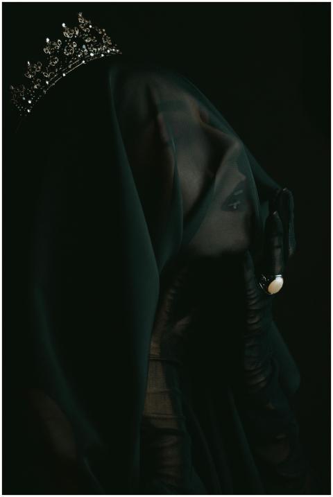 Ethereal portrait of a veiled woman wearing a crow