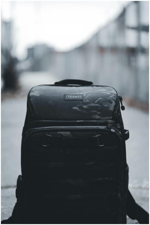 Close-up of a black backpack on urban pavement, ca