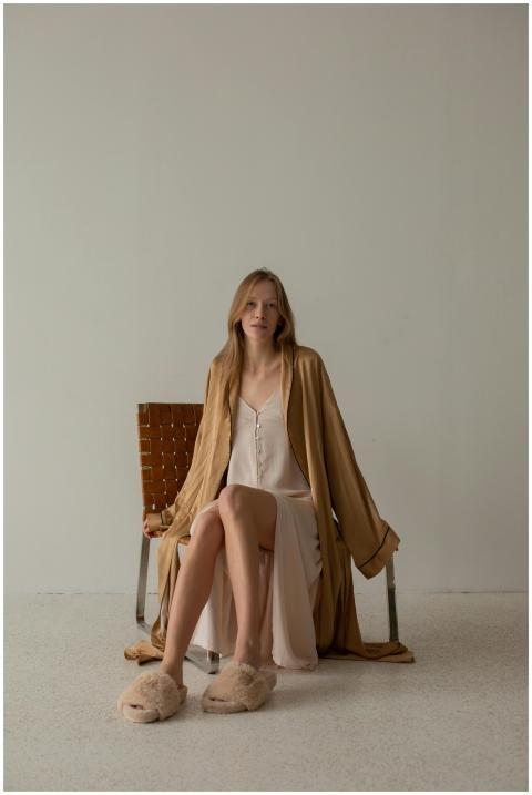 Stylish woman in comfy robe and slippers, indoors,