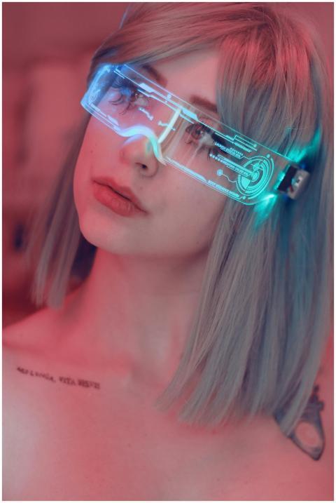 Portrait of a young woman wearing neon light glass