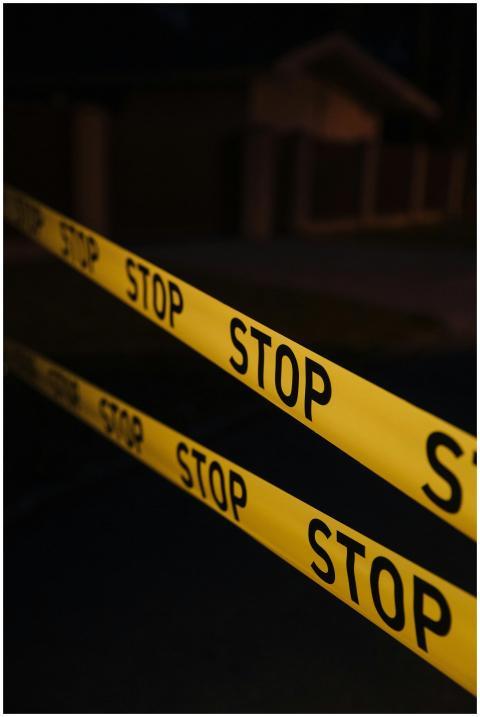 Yellow stop tape in a night crime scene setup, cre